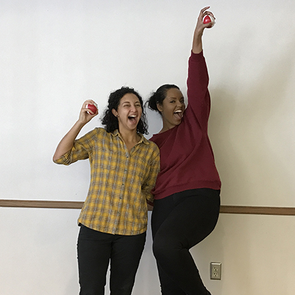 Two female college students celebrating after successful partner juggling.